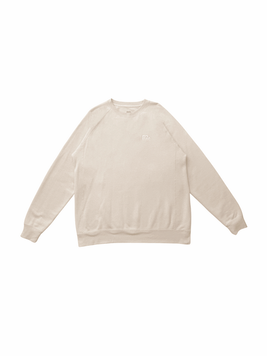 flat lay of creme color crewneck sweater with same tone color GODinme logo at left chest