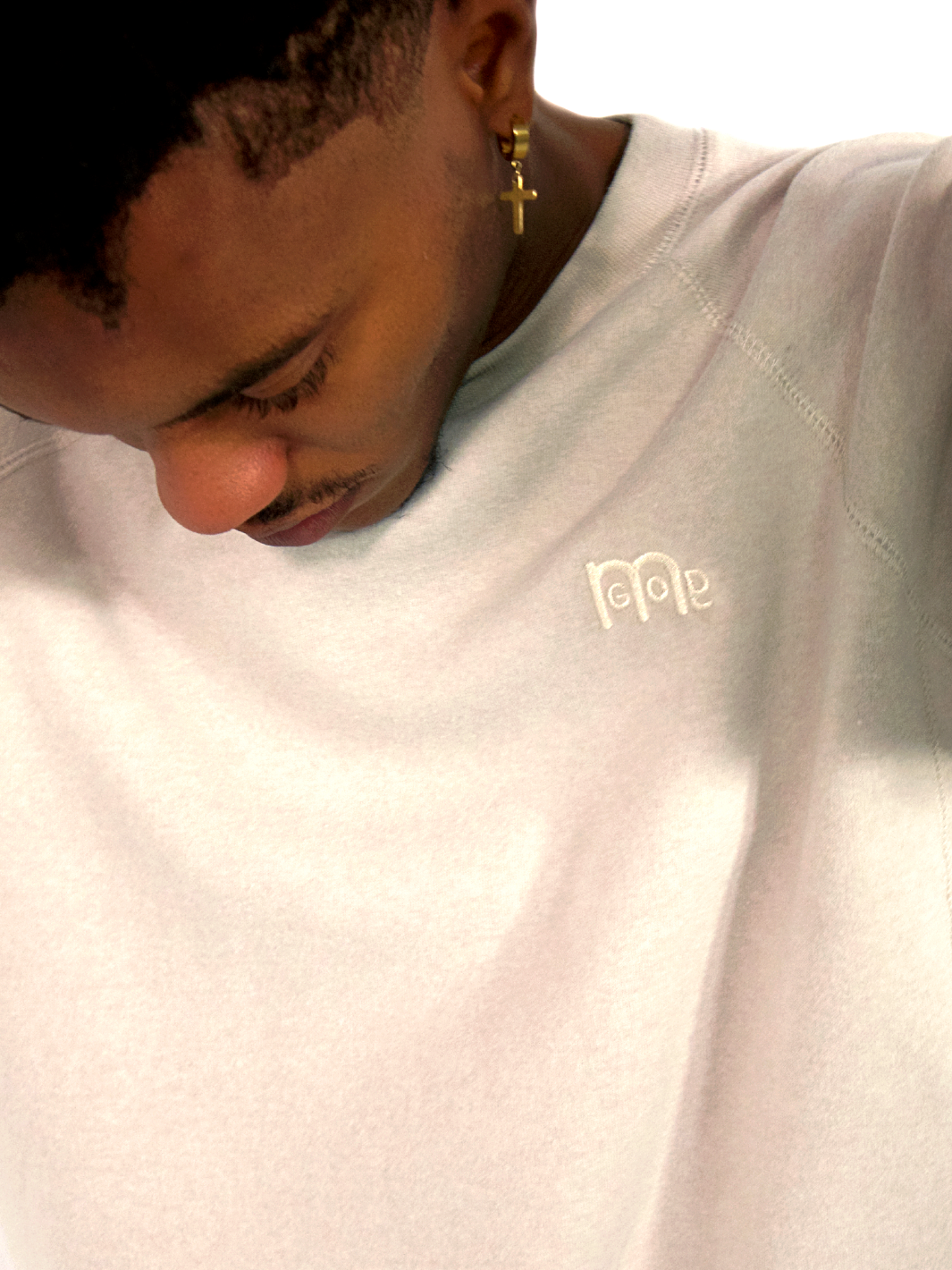 Close up of GODinme logo on Creme color  GODinme Crewneck Sweater.