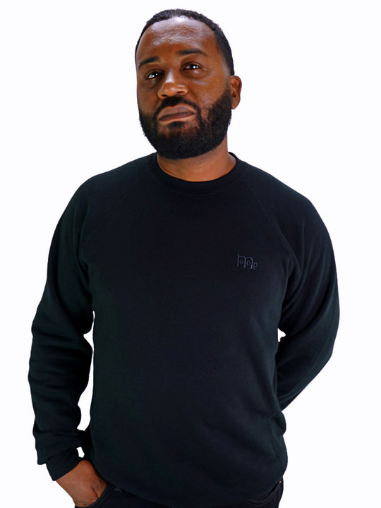 Model wearing GODinme Crewneck Sweater with raglan sleeves and embroidered Black GODinme logo at left chest.