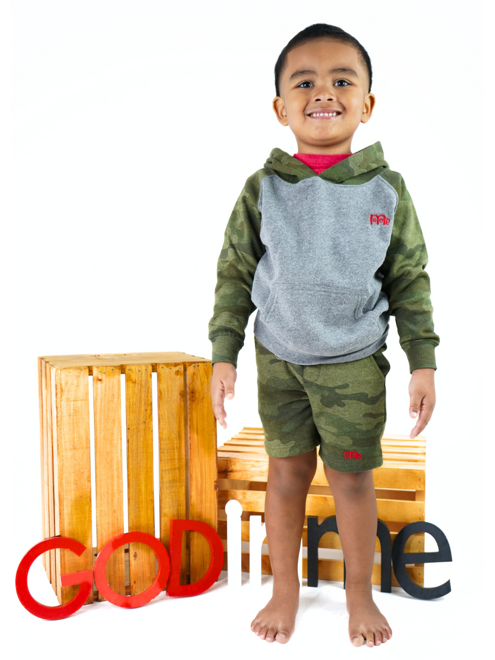 Toddler size Green Camouflage Shorts with elastic waistband, sewn fly detail, jersey-lined front pockets, stylish back pocket, and Red GODinme logo.