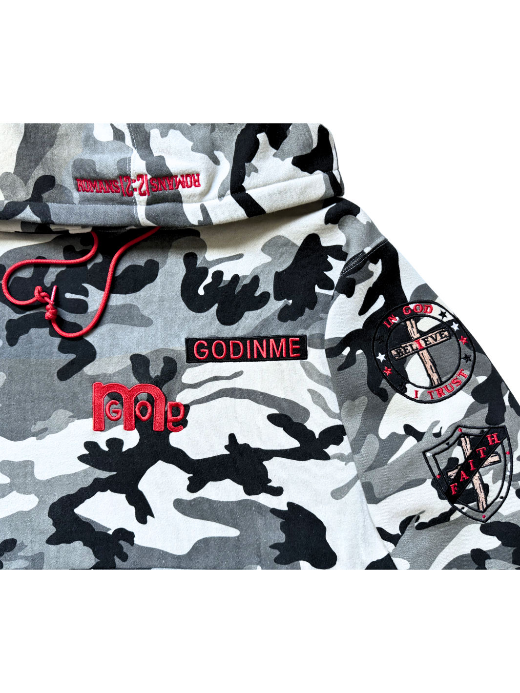 Close-up of a Red embroidered GODINME nameplate, a large GODinme logo, and two patches on a Black, White, and Grey camouflage pullover hoodie.