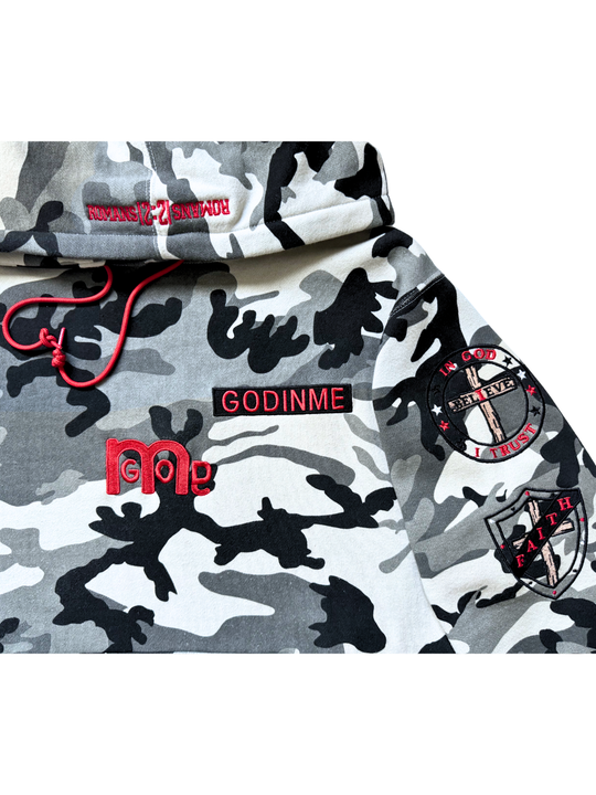 Close-up of a Red embroidered GODINME nameplate, a large GODinme logo, and two patches on a Black, White, and Grey camouflage pullover hoodie.