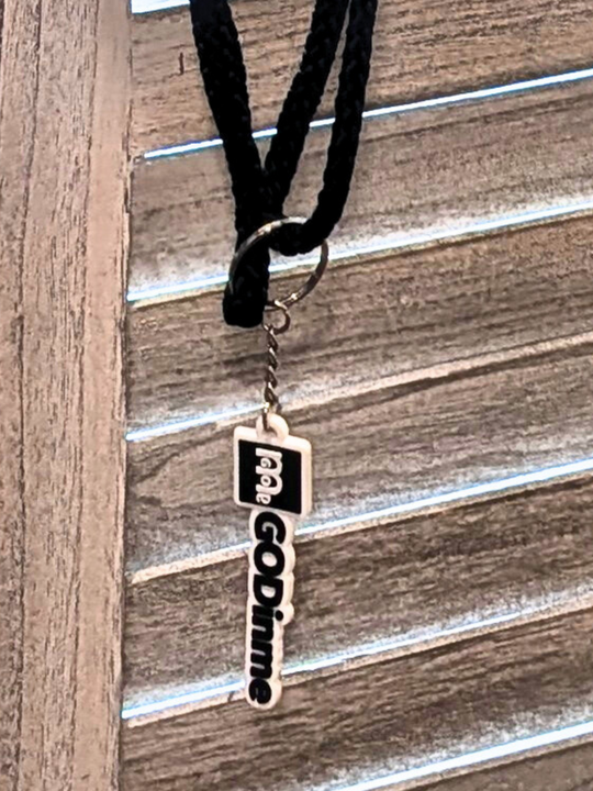 Close-up of GODinme keychain attached to drawstring backpack.