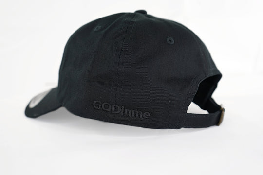The forever popular Black 6 panel unstructured Dad Hat has Black curved under visor and antique Brass buckle closure. Embroidered in Black is the GODinme Logo on front and GODinme name on left side.