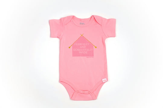 Pink Infant Onesie with "Fearfully and Wonderfully Made" printed on front and woven tag GODinme logo at left leg.