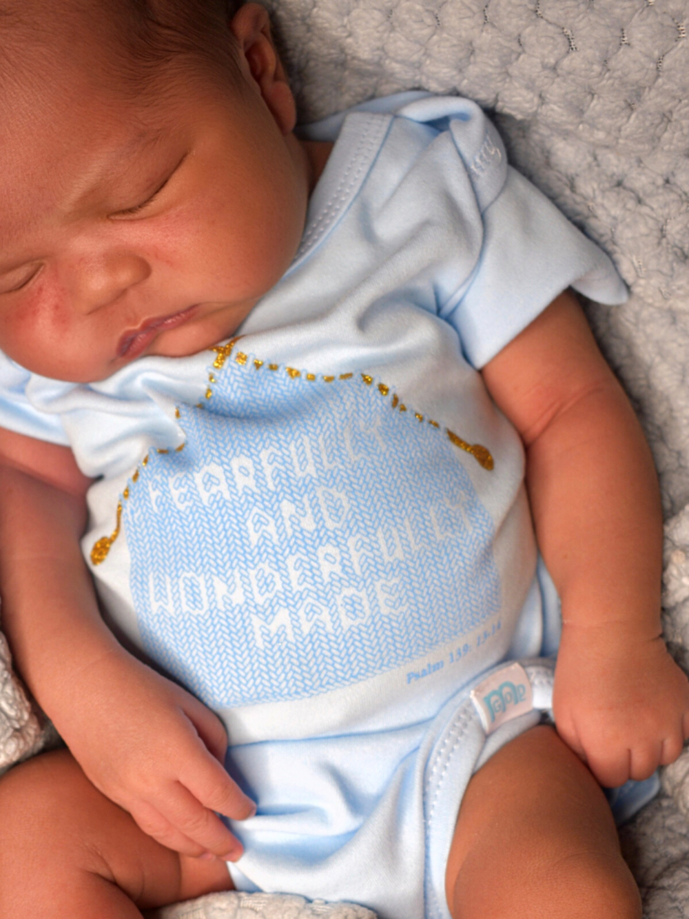 Blue Infant Onesie with "Fearfully and Wonderfully Made" printed on front and woven tag GODinme logo at left leg.