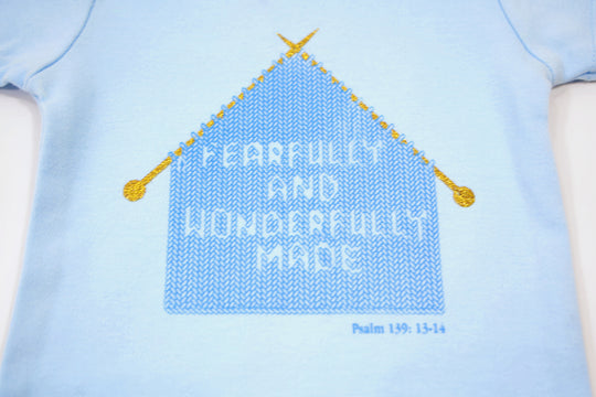 Blue Infant Onesie with "Fearfully and Wonderfully Made" printed on front and woven tag GODinme logo at left leg.